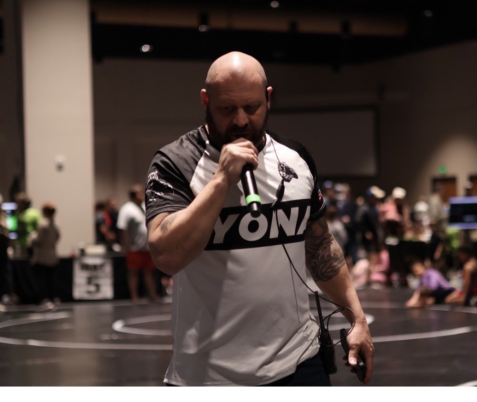 Heath Earley speaking at a wrestling tournament